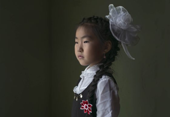 photographie d'une petite fille avec une tresse et un fond vert par la photographe Claudine Doury