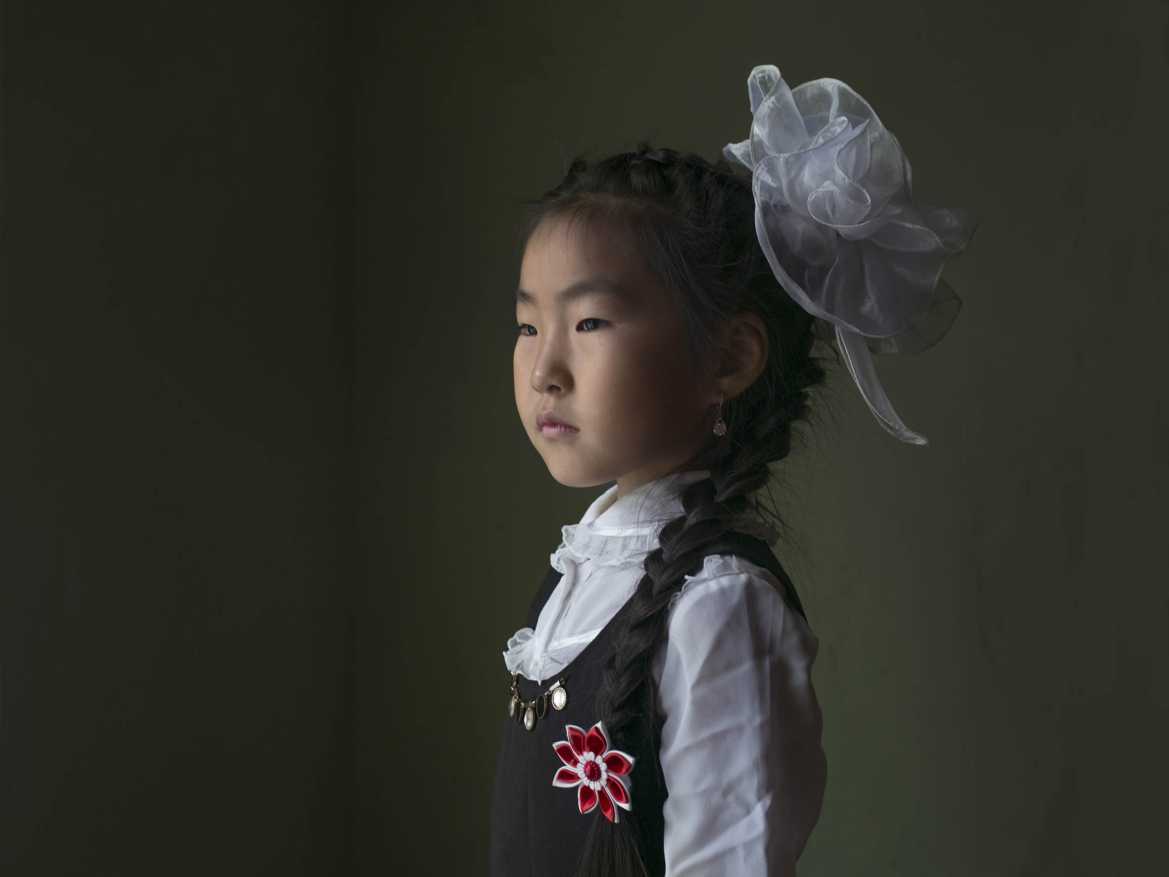 photographie d'une petite fille avec une tresse et un fond vert par la photographe Claudine Doury