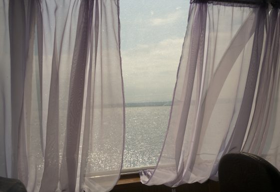photographie d'une fenêtre avec la mer au loin par la photographe Claudine Doury