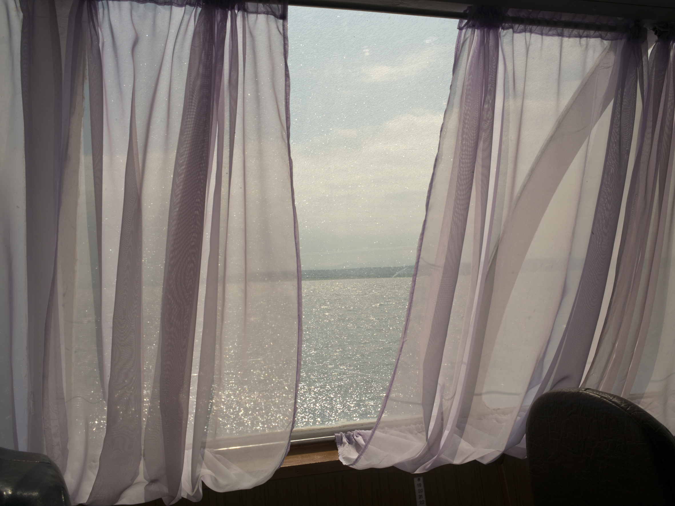 photographie d'une fenêtre avec la mer au loin par la photographe Claudine Doury
